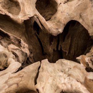 Mesa de centro Waary de estilo étnico fabricado en raíz teka en color marrón con acabado envejecido combinado con vidrio. Producto desmontable.