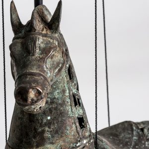 Figura decorativa Caballo de estilo contemporáneo fabricado en madera tropical en color gris con acabado envejecido combinado con bronce. Producto desmontable.