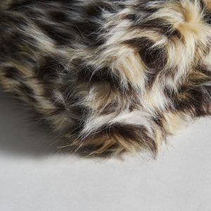 Manta Tigre de estilo nórdico fabricado en microfibra en color marrón en color beige.