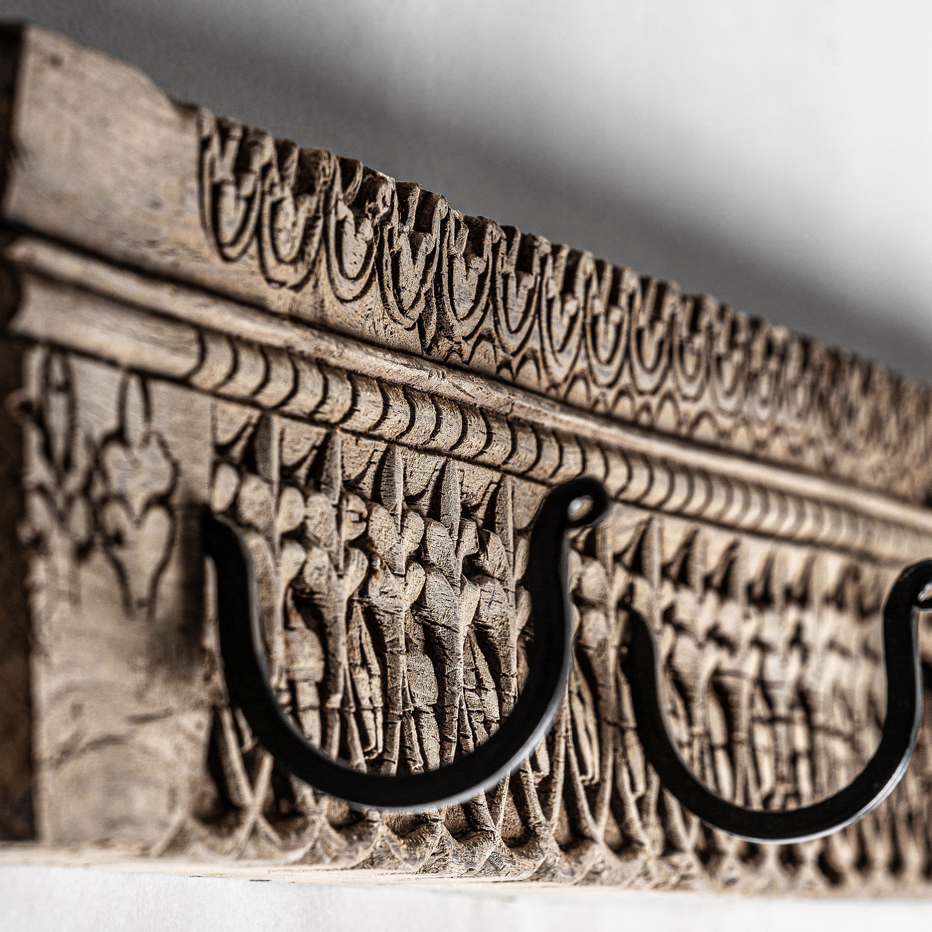 Percha Cain de estilo étnico fabricado en madera de teka en color marrón combinado con hierro en color negro.