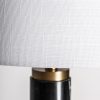 Lámpara de pie de estilo art deco fabricado en mármol en color negro combinado con acero en color oro con acabado bronce y poliéster en color blanco. Producto desmontable.