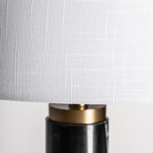 Lámpara de pie de estilo art deco fabricado en mármol en color negro combinado con acero en color oro con acabado bronce y poliéster en color blanco. Producto desmontable.