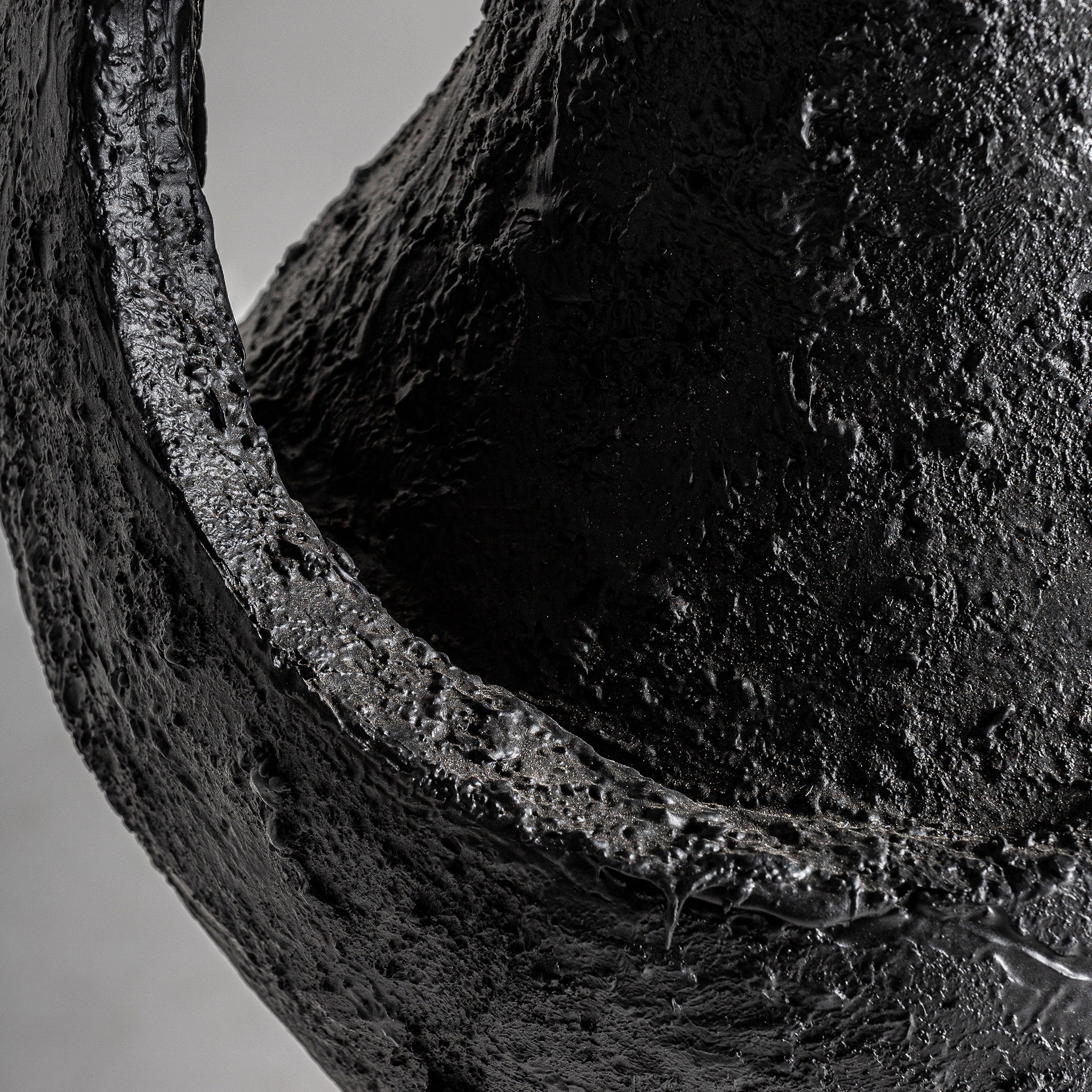 Jarrón riley de estilo contemporáneo fabricado en resina en color negro.