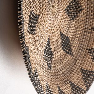 Plato decorativo de estilo boho fabricado en ratán en color tonos en marrón.