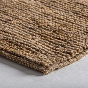 Alfombra tish de estilo boho fabricado en yute en color tonos en marrón combinado con algodón.