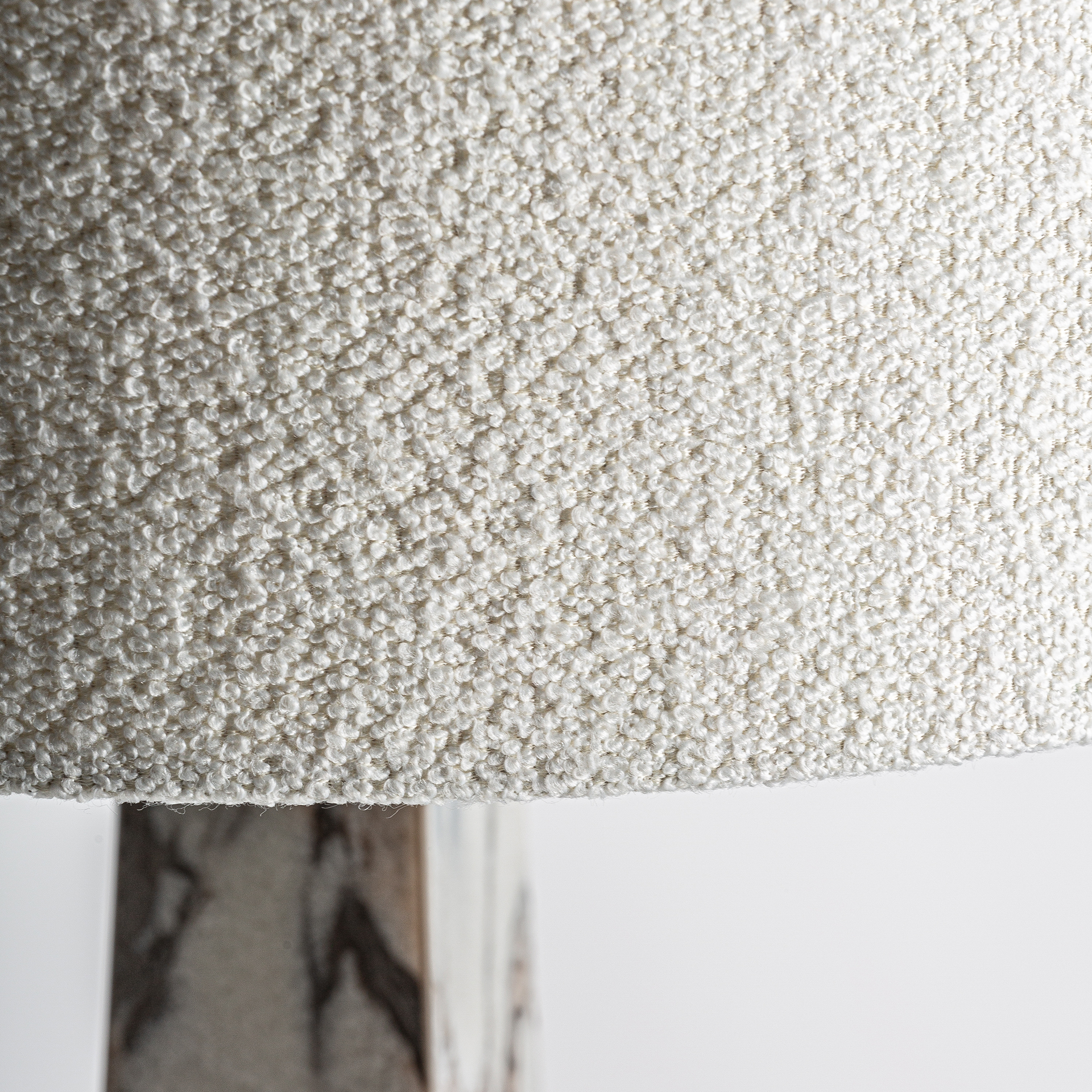 Lámpara de sobremesa Dina de estilo art deco fabricado en mármol en color blanco combinado con hierro en color negro y algodón bouclé en color blanco. Producto desmontable.