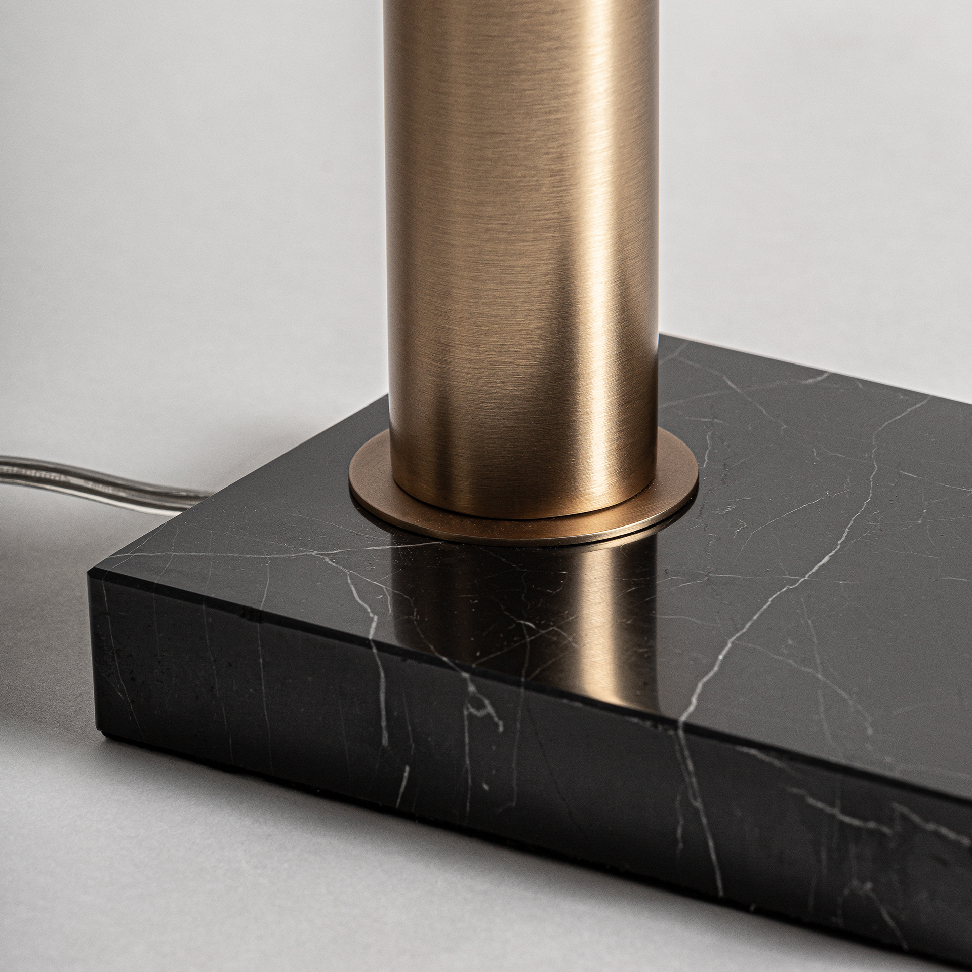 Lámpara de sobremesa Akros de estilo art deco fabricado en hierro en color negro combinado con mármol en color oro.