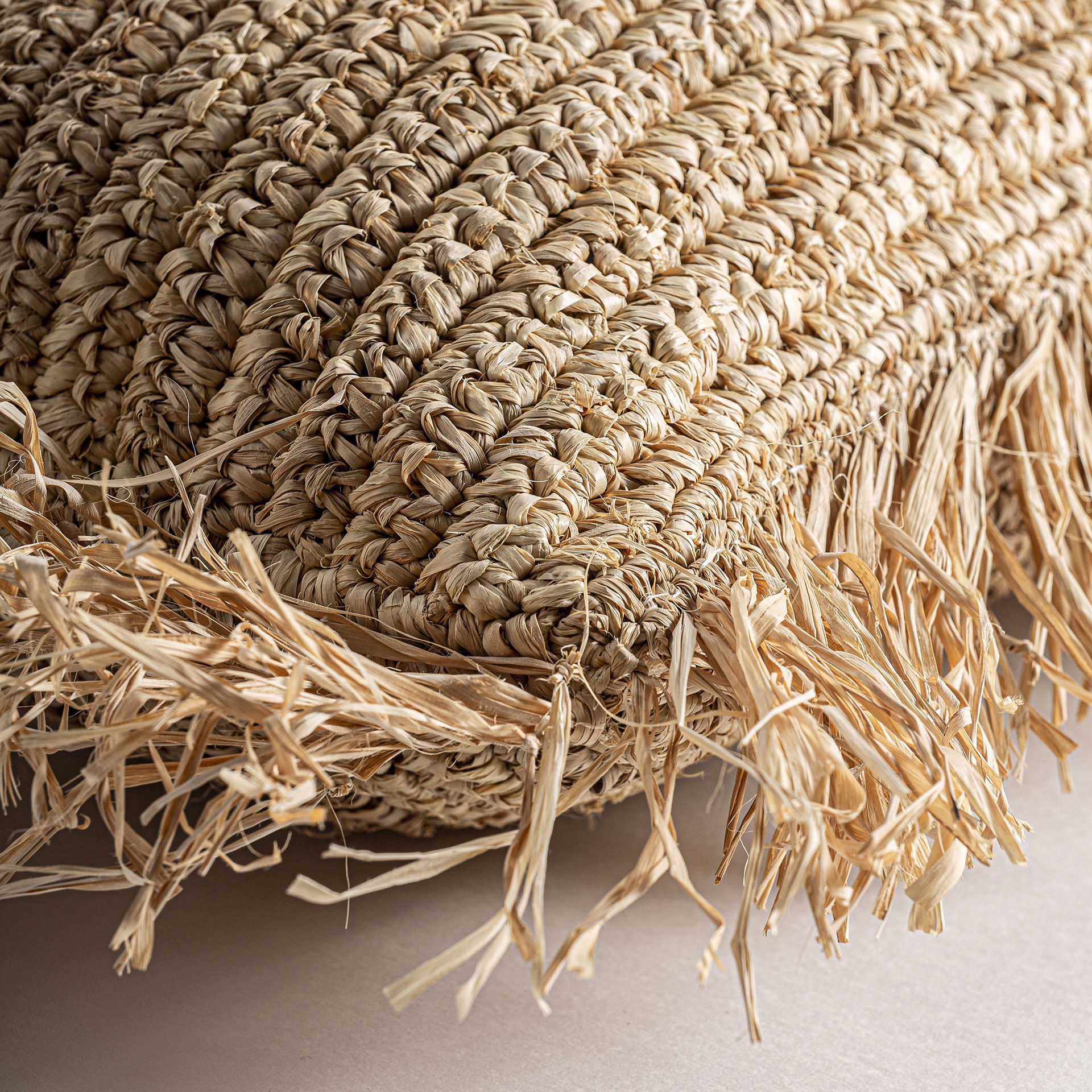 Cojín igotz en color beige de estilo boho. Fabricado en fibra natural combinado con poliéster.