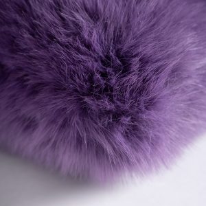 Cojín tropez de estilo contemporáneo fabricado en poliéster en color morado. Relleno de fibra y pluma de pato. Producto desenfundable.