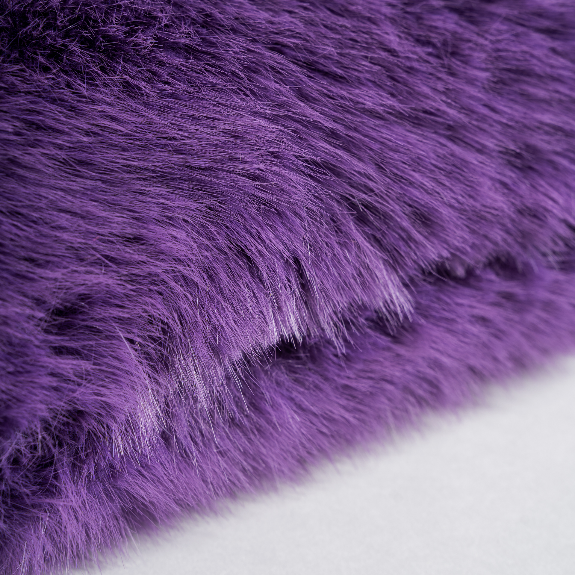 Cojín tropez de estilo contemporáneo fabricado en poliéster en color morado. Relleno de fibra y pluma de pato. Producto desenfundable.