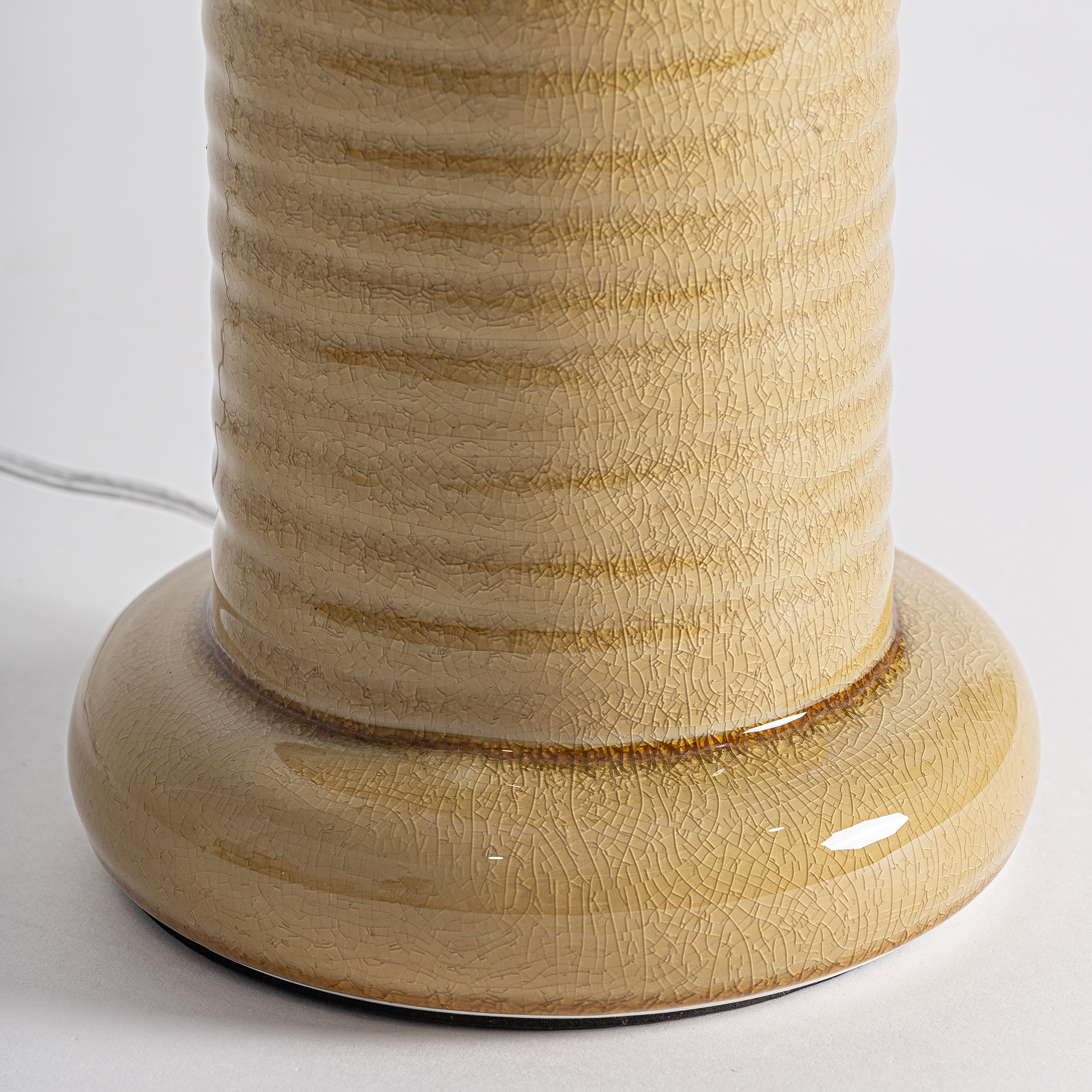 Lámpara de sobremesa Blanes de estilo contemporáneo fabricado en cerámica en color ocre combinado con lino en color beige y hierro en color oro.