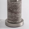Lámpara de sobremesa Xilka de estilo art deco fabricado en travertino en color tonos neutros combinado con hierro en color plata y lino en color gris. Producto desmontable.