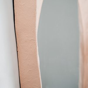 Espejo Budel de estilo contemporáneo fabricado en resina en color rosa.